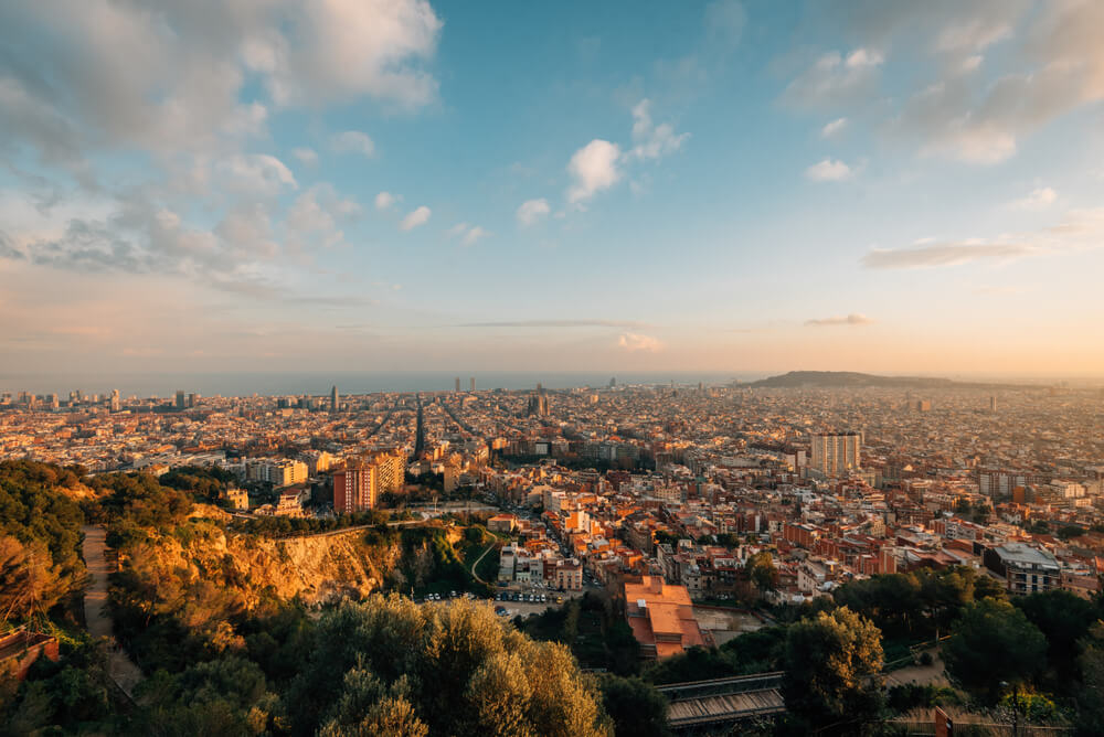 Aussichtspunkte Barcelona: Abenddämmerung über der Stadt mit dem Meer im Hintergrund.