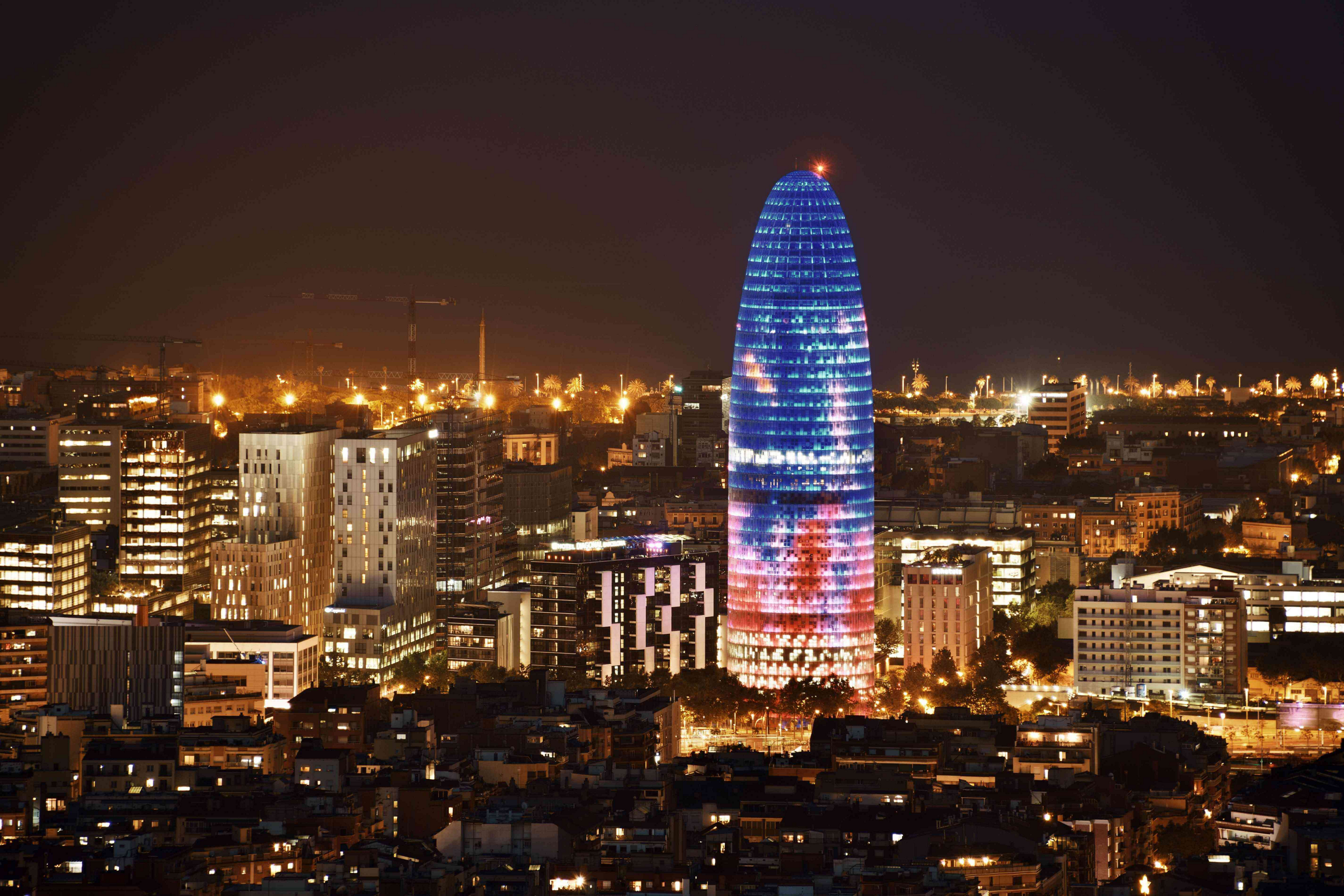 Barcelona nightlife: Barcelona skyline lit up at night with a view of the Torre Glòries