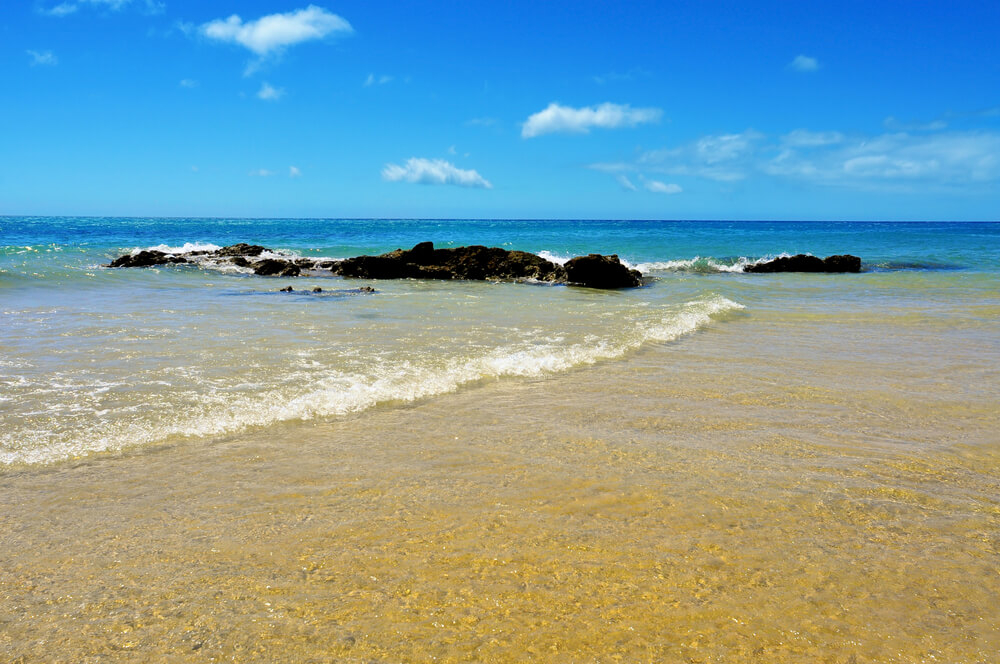 Playa Esmerelda: Blue ocean and golden sand with a volcanic rock in the centre