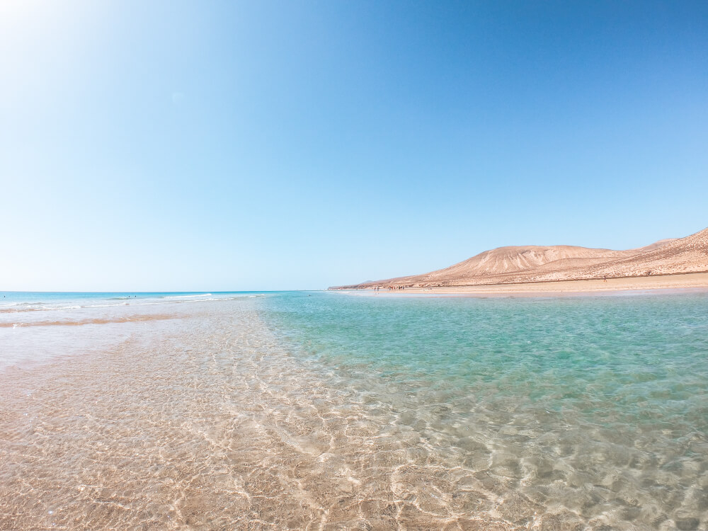 Sotavento Beach: Wide stretch of white sand and clear water with white hills