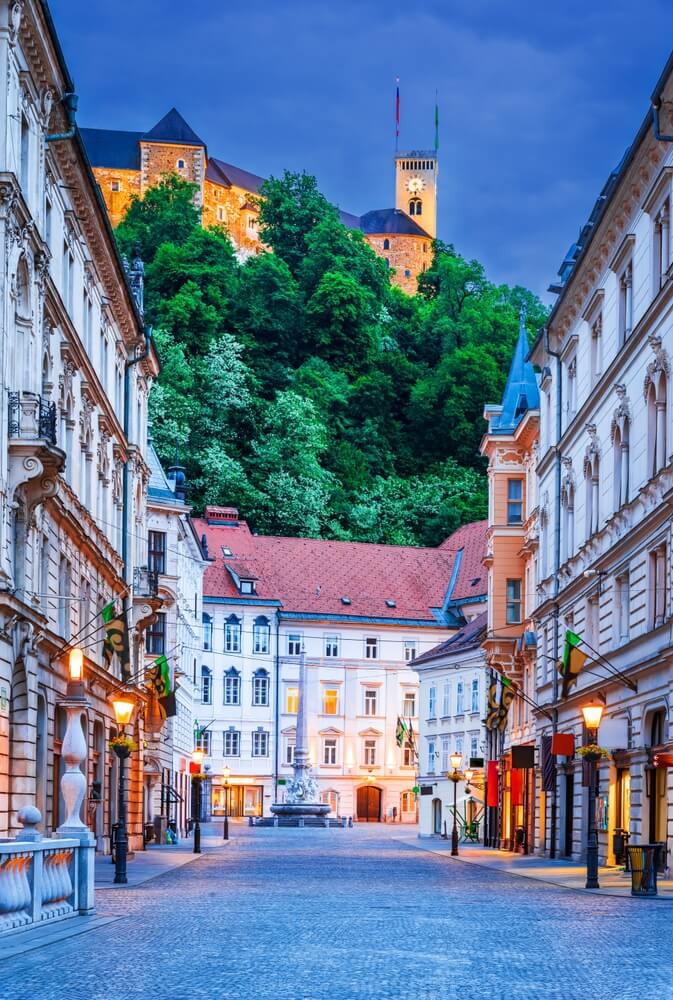 Best holidays for teenagers: A typical Ljubljana street lit up at night with mountains