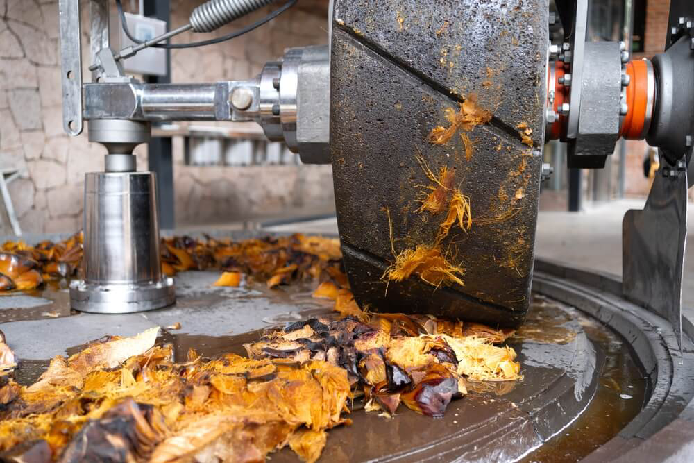 Best tequila in Mexico: A roller crushing cooked agave in a tequila factory