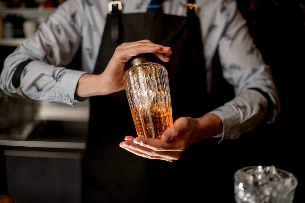 Caribbean cocktails: Man dressed elegantly holding a cocktail shaker 