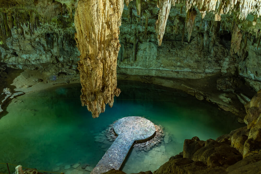 Das Cenote Suytun von oben gesehen mit Tropfsteinen im Vordergrund.