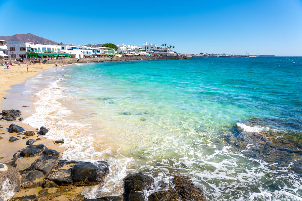 Playa Blanca: White sand beach with turquoise waters lined with white buildings