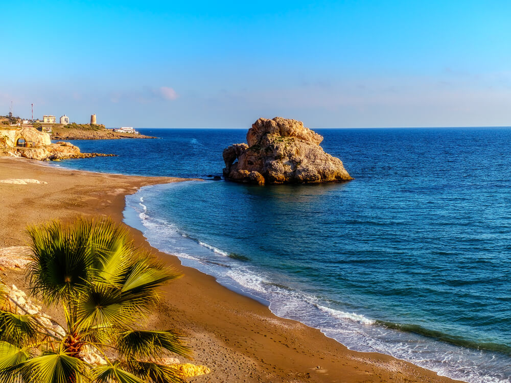 Der Playa Peñón del Cuervo in Málaga mit seinem charakteristischen Felsen.