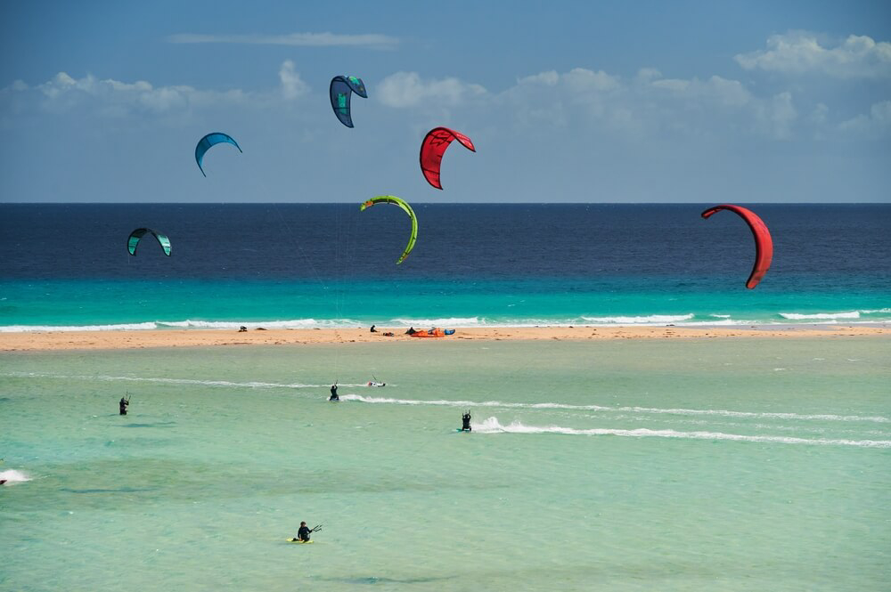 Kitesurf with kids: The sea full of kitesurfers at Sotavento Beach in Jandía, Fuerteventura