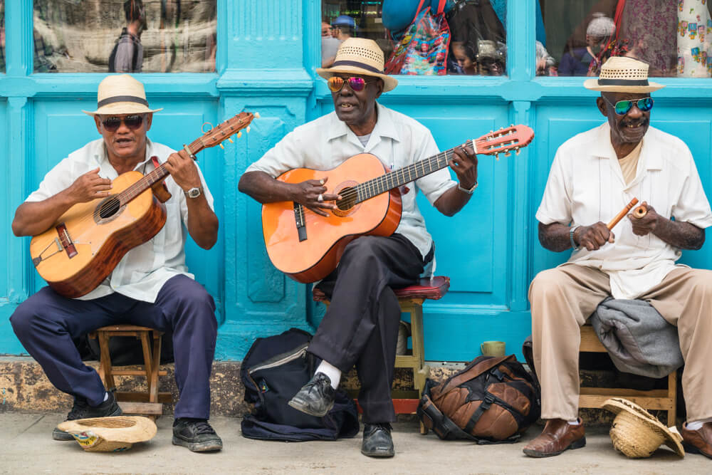 Hemingway Cuba: A close-up of three street musicians playing instruments in Havana, Cuba