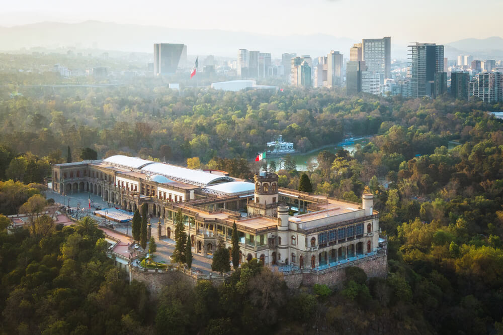 An aerial view of Chapultepec Castle, nestled amongst leafy green trees.