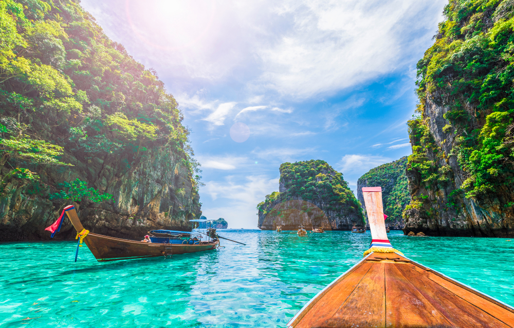 Maya Bay Phi Phi Islands: Wooden boats on turquoise water surrounded by green mountains