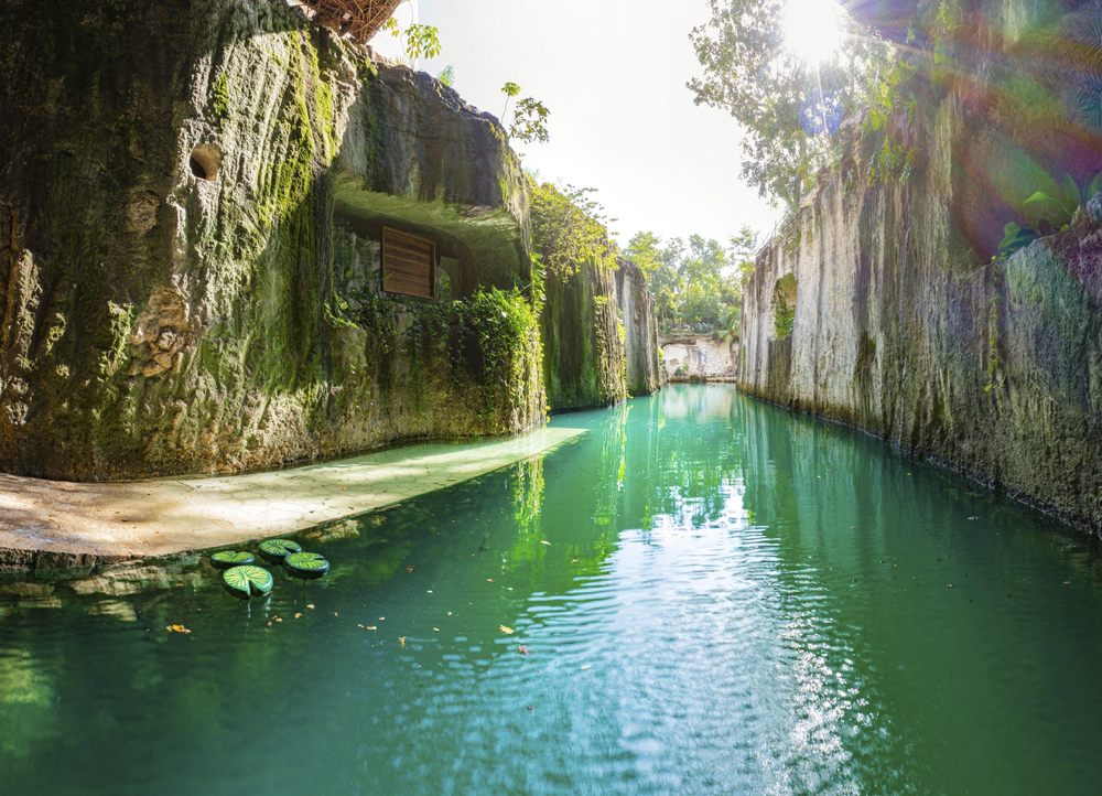 A photo of a beautiful waterway, featuring mossy cliffs and turquoise waters.