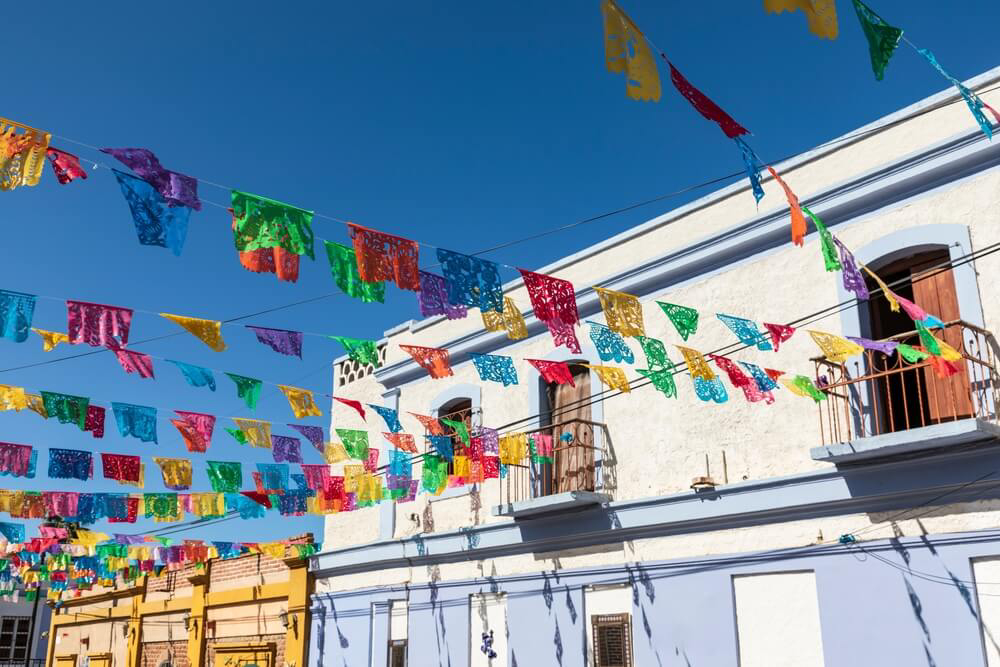 Bunte Fahnen über der Straße im mexikanischen Dorf Todos Santos.