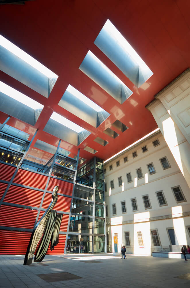 Museums in Madrid: Red roof and white walls of the Reina Sofía gallery facade with statue