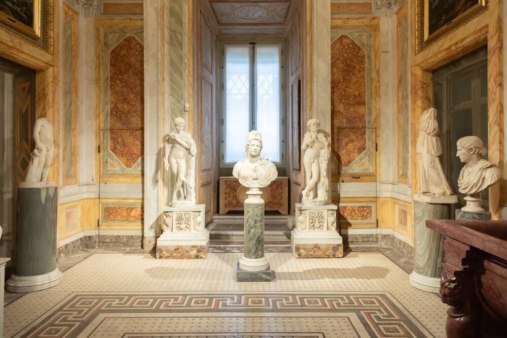 Museums in Rome: Yellow marble hall of the Borghese Gallery with white marble bust statues