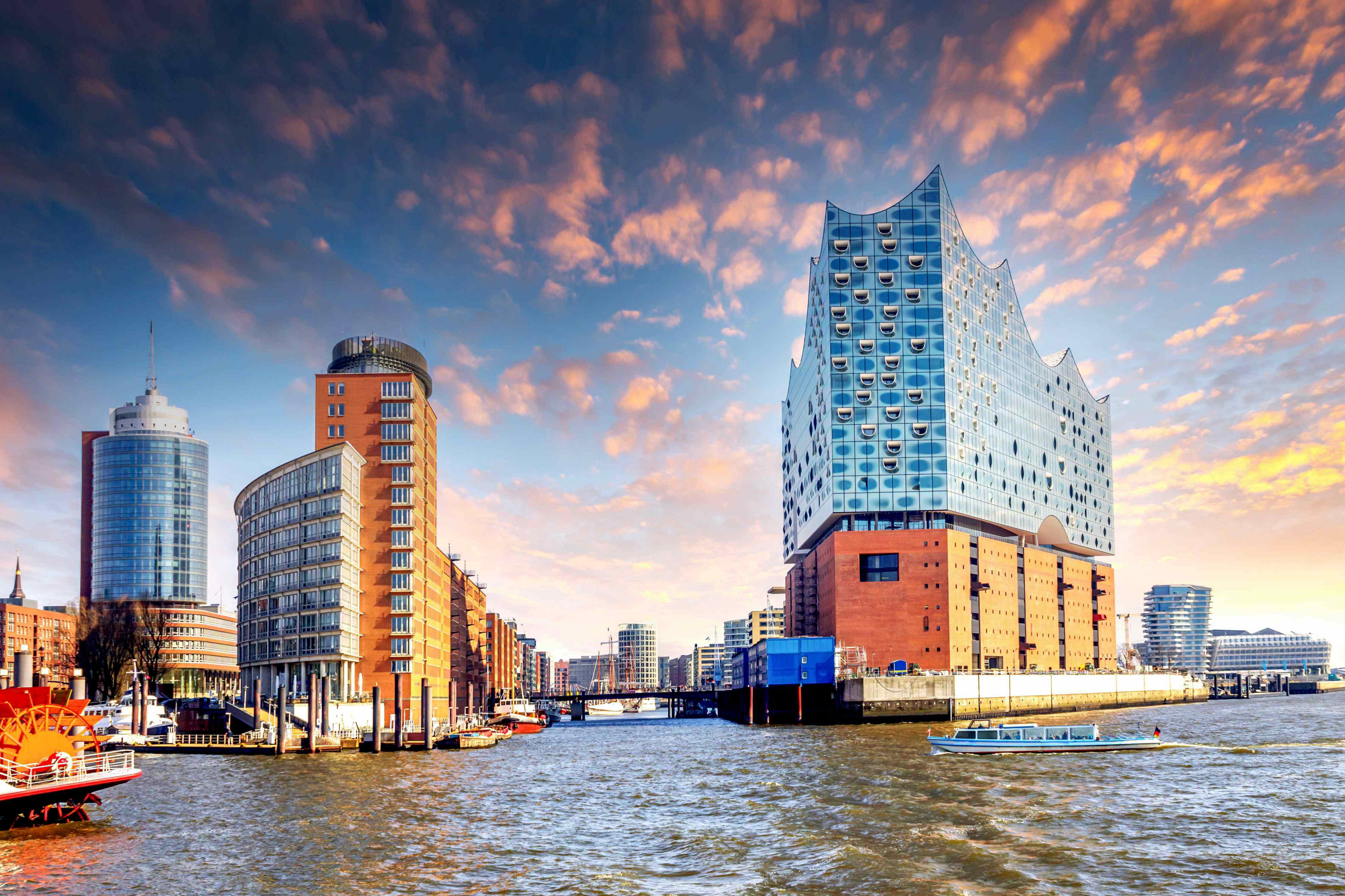 Things to do in Hamburg: A view of tall, modern, glass and brick buildings by the riverside