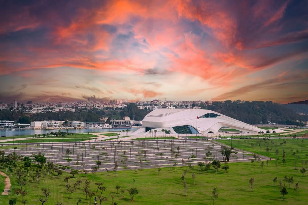 Futuristisches Theatergebäude in Rabat in der Dämmerung mit der Stadt im Hintergrund.