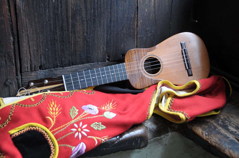 Romerías Tenerife: A timple and traditional Canarian clothing on a wooden surface