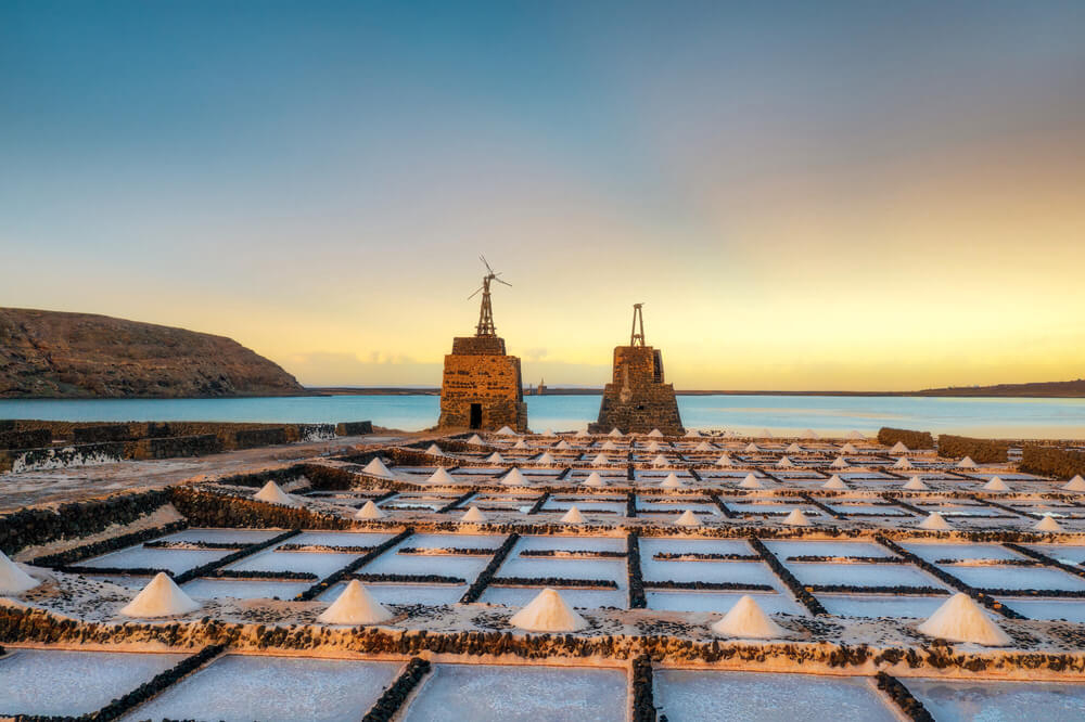 Salinas del Janubio: Sun setting over the salt flats with the sea in the background