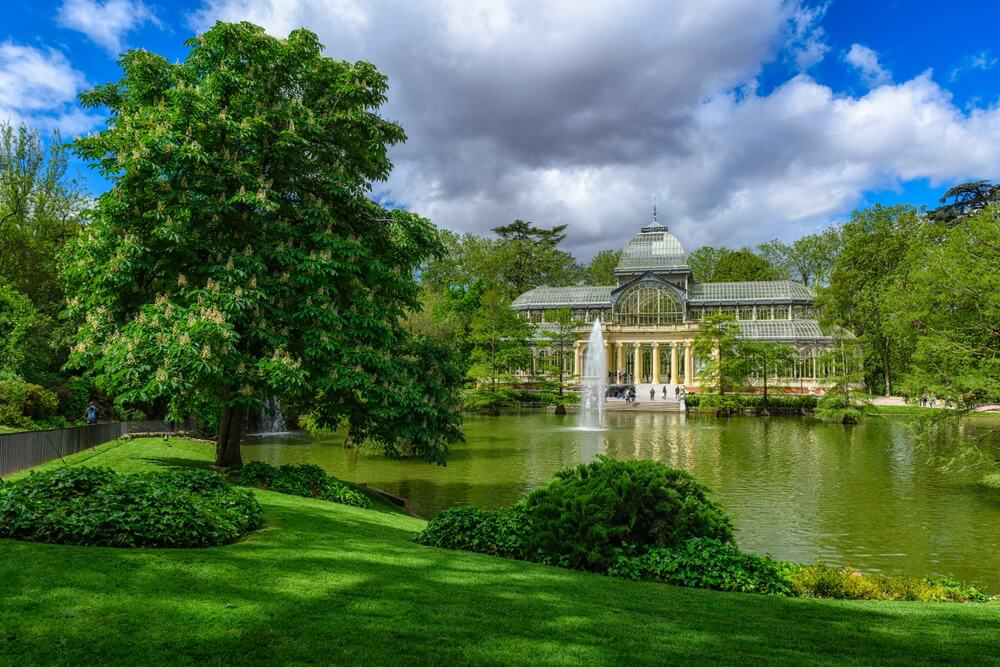 Der Retiro-Park in Madrid mit dem Kristallpalast und seinem See im Vordergrund.