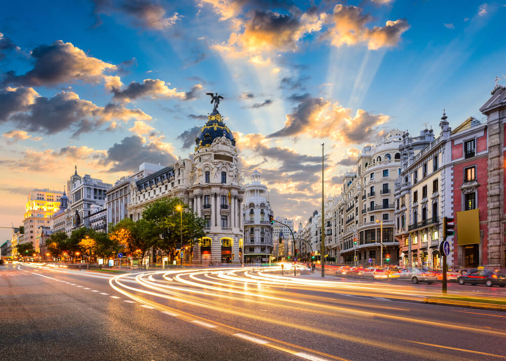 Beleuchtete Straße in Madrid in der Abenddämmerung.