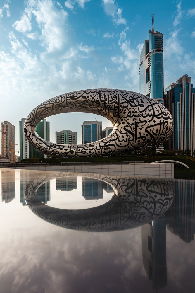 Dubai modern architecture: A silver bean-shaped building against a modern skyline