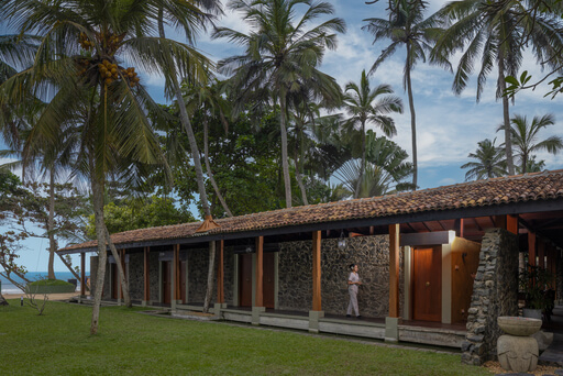 Occidental Eden Beruwala: A close-up of the hotel overlooking a lawn surrounded by palm trees