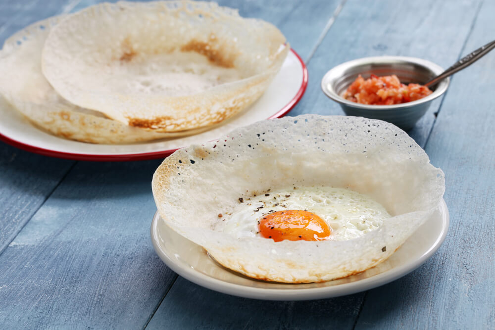 Street food in Sri Lanka: A freshly made hopper shell with a runny egg in the centre