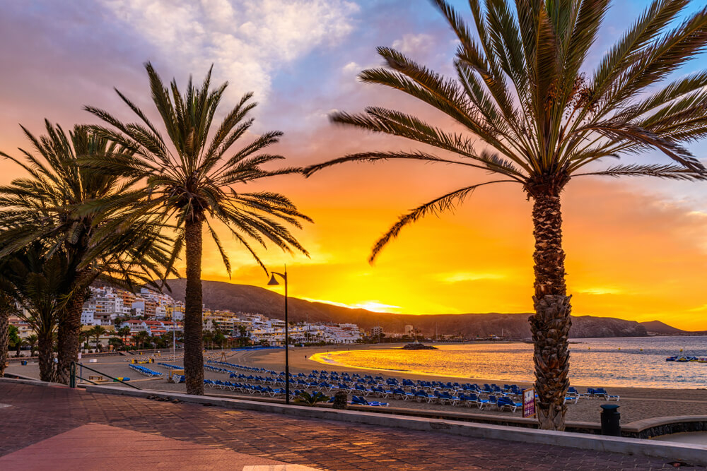 Teneriffa schönste Strände: Strandpromenade mit Palmen in der Dämmerung.