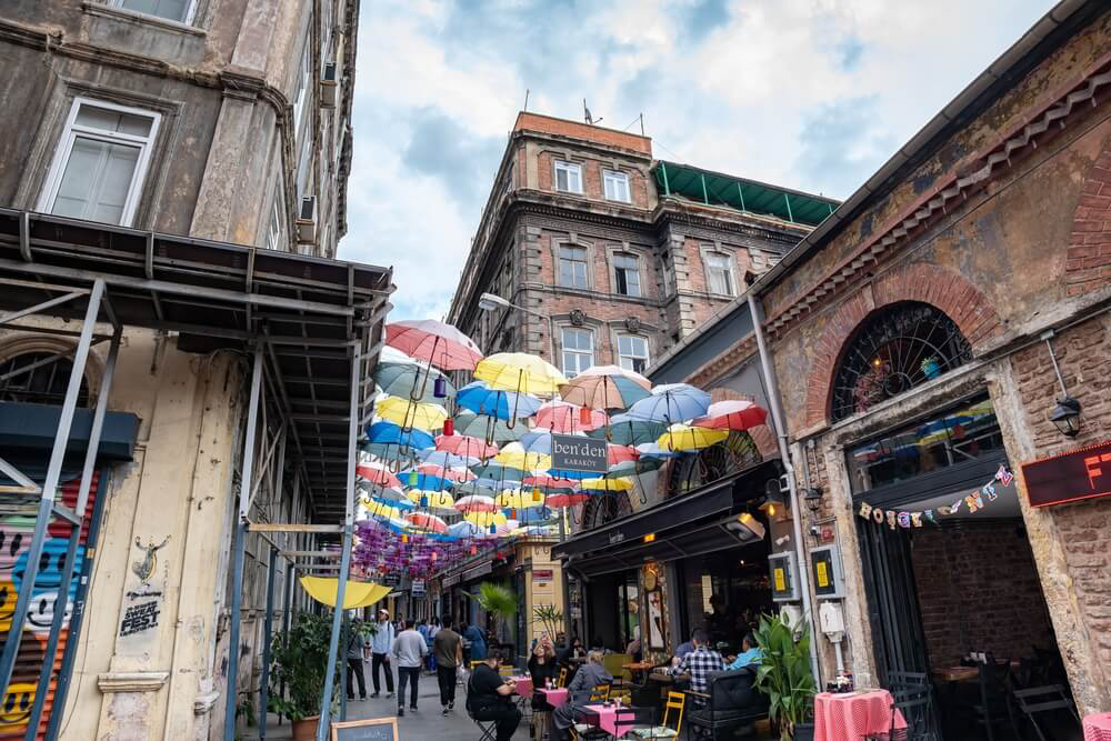 Inner city streets full of people with multi-coloured umbrella-covered walkways