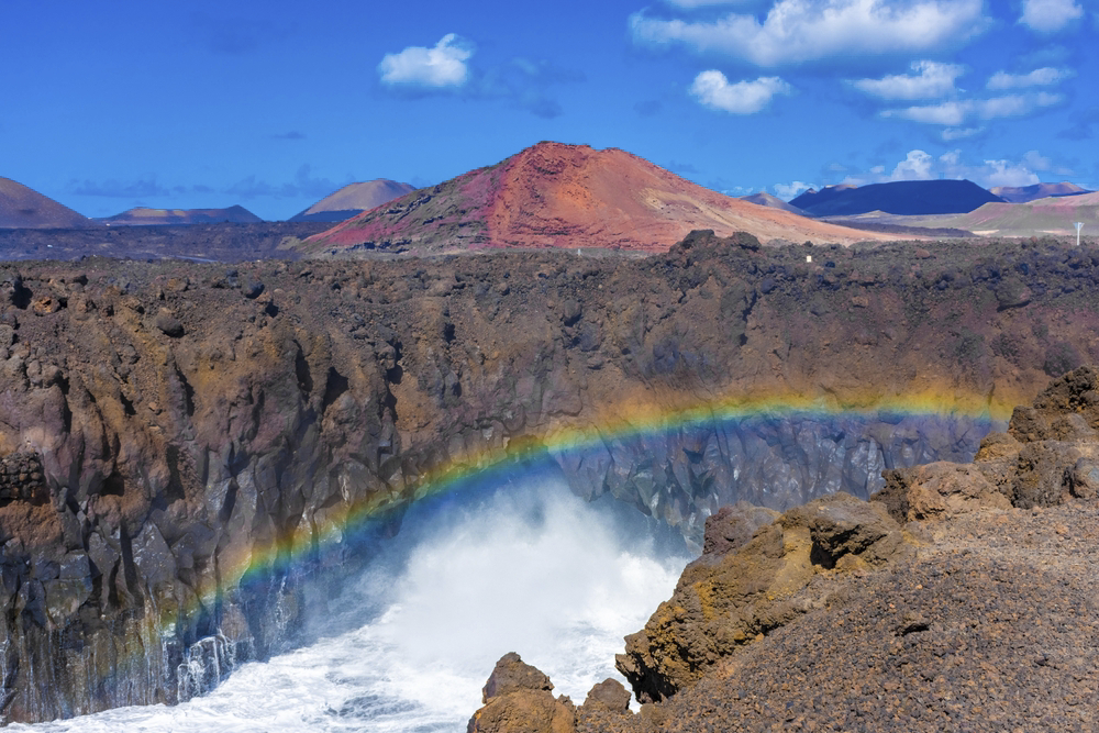 Los Hervideros: Impressive cliffs with the ocean splashing against them and a rainbow