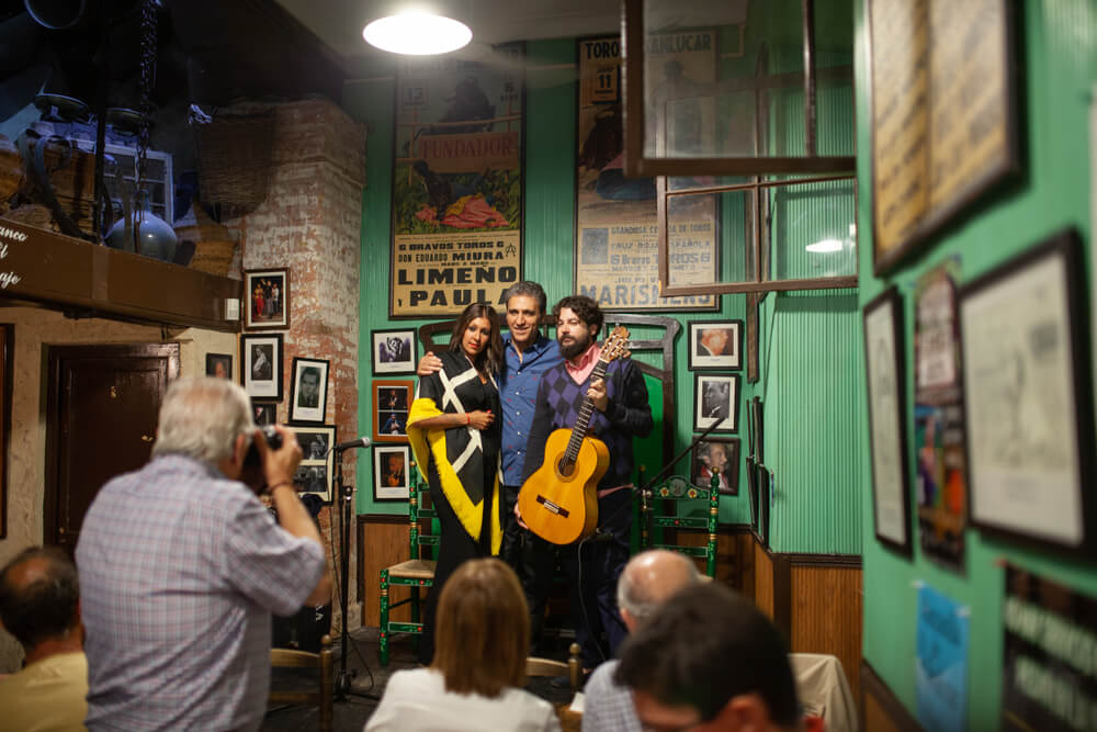 Tabanco: Three people on a makeshift stage in a green bar