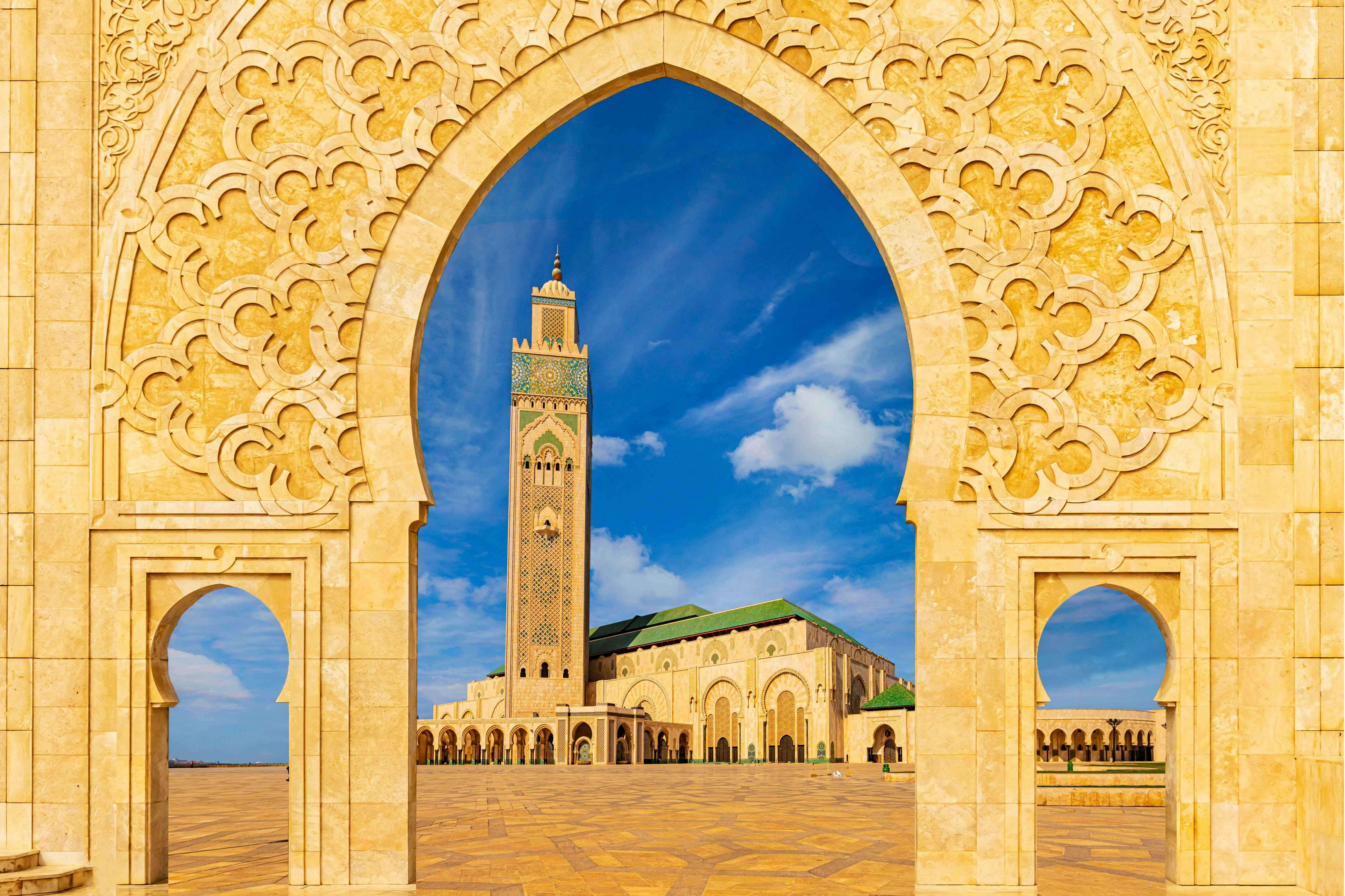 What to do in Casablanca: A view of the Hassan II Mosque through an ornate arch