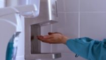 Photo of hands at a disinfectant dispenser