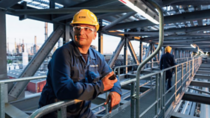 BASF engineer at a production site looking towards the sun 