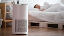 woman sleep with Air purifier in cozy white bed room for filter and cleaning removing dust PM2.5 HEPA in home,for fresh air and healthy life,Air Pollution Concept