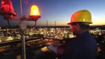 engineer working at BASF production site at night overlooking the city 