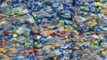 Hundreds of plastic water bottles compacted together at a recycling plant 