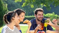 Group of people laughing and having a picnic cheer-sing cups 