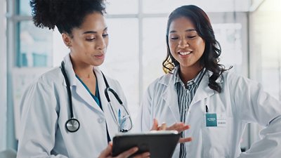  Antimicrobial Resistance & Stewardship Photo of two female doctors discussing in front of a whiteboard