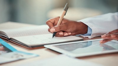  Acute Kidney Injury Photo of a female doctor's hand looking at an iPad and taking notes