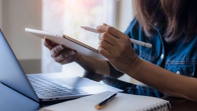 Microbiology Photo of a female nurse studying on her computer and taking notes