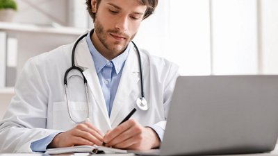  Antimicrobial Resistance & Stewardship Doctor watching webinar on laptop and taking notes.