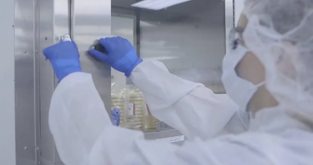 Screenshot from 3p Manufacturing Video, person wokring in lab opens cabinet 