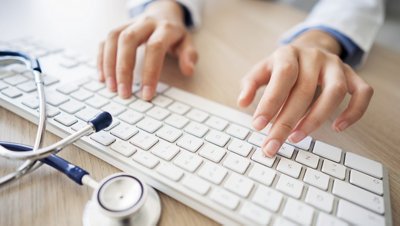 Female doctor typing on computer