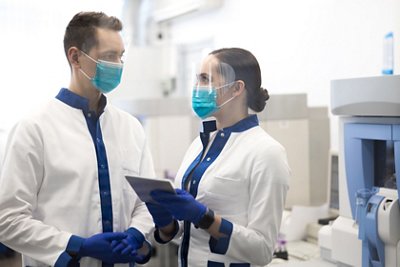 Female researcher holding digital tablet while talking with male colleague stock photo