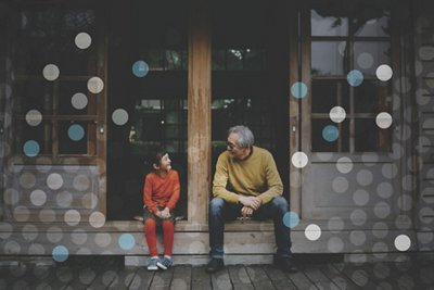 Young child looking up and smiling at their grandfather