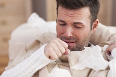 Sick man lying on sofa in living room 