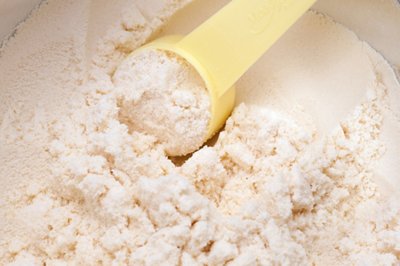 close up of powdered milk and spoon for baby on white background with clipping path