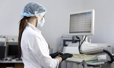 Clinical lab tech reviewing diagnostic test results on computer