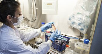 Lab worker in mask picks up sample